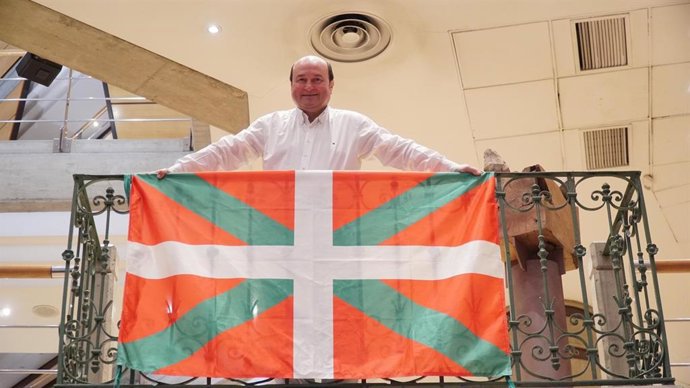 El presidente del EBB del PNV, Andoni Ortuzar, coloca una ikurriña en el balcón original e la casa de Sabino Arana en su sede de Bilbao