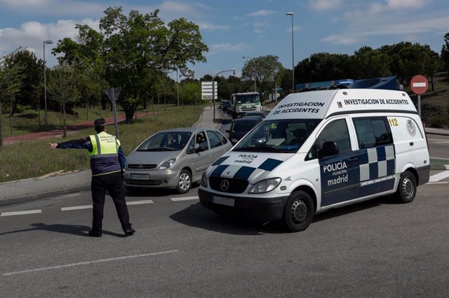 Un agente de la Policía Municipal regula el tráfico en un control policial en el barrio madrileño de Vallecas durante una Semana Santa atípica en la que prosigue el estado de alarma decretado por el Gobierno para la lucha contra el coronavirus.