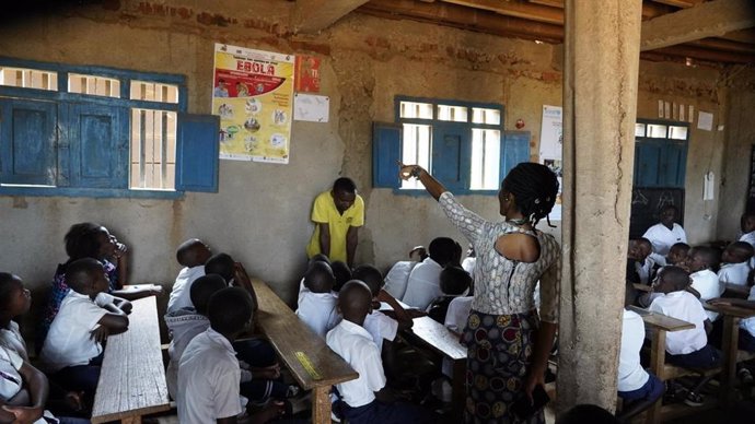 Niños en una escuela de RDC con un cartel sobre el ébola.