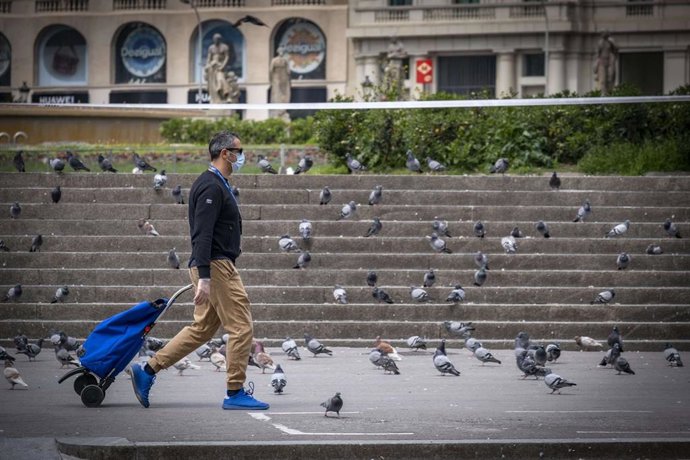 Un hombre yendo a comprar durant el confinamiento por el coronavirus en Barcelona.
