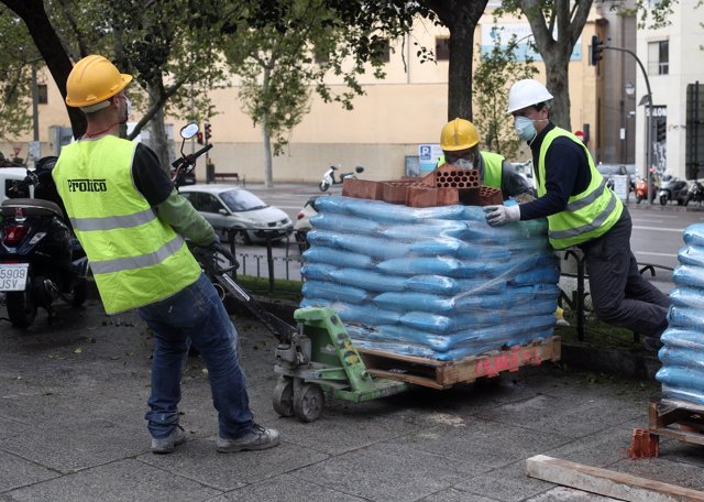 Varios obreros empujan material de construcción antes de entrar en un edificio en la Calle Gran Vía de San Francisco el día en el que se reactiva la actividad laboral no esencial.