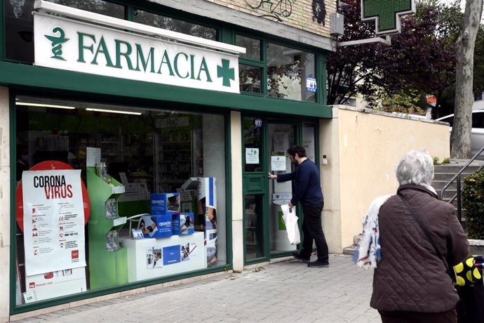 Un hombre entra en una Farmacia, abierta por ser esencial