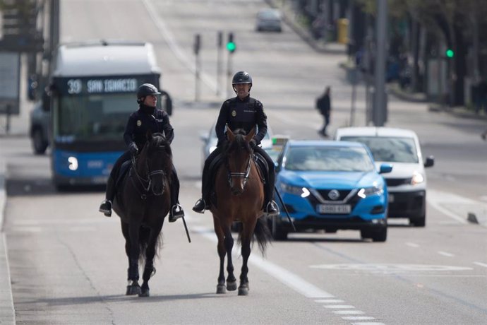 Dos agentes de la Policía Nacional vigilan a caballo las calles de la capital durante una Semana Santa atípica