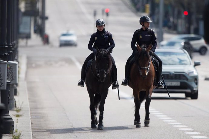 Dos agentes de la Policía Nacional vigilan a caballo las calles de la capital durante una Semana Santa atípica en la que prosigue el estado de alarma decretado por el Gobierno para la lucha contra el coronavirus, en Madrid (España) a 8 de abril de 2020