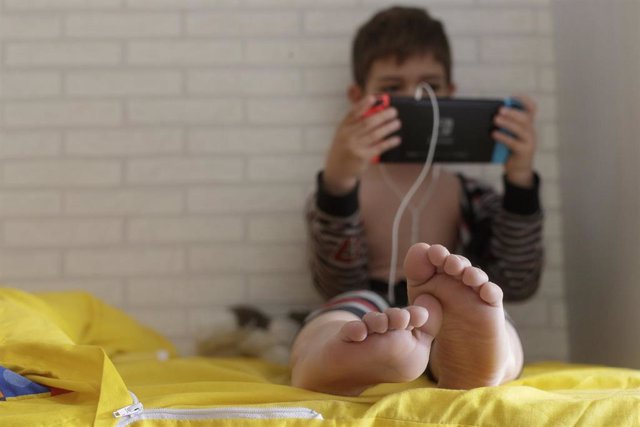 Un niño de 8 años juega y habla con sus amigos a través de una videoconsola, en Madrid (España) a 12 de abril de 2020.