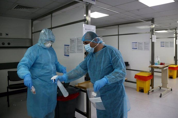08 April 2020, Lebanon, Beirut: A nurse sterilizes a doctor after performing a PCR test on a patient at the Coronavirus emergency ward at Rafiq Hariri University Hospital. Photo: Marwan Naamani/dpa