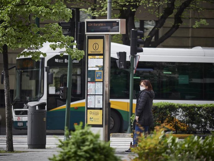 Una mujer camina con mascarilla por la Avenida Carlos III, vacía durante el día en el que se reactiva la actividad laboral no esencial en las empresas cuyos empleados no puedan teletrabajar 