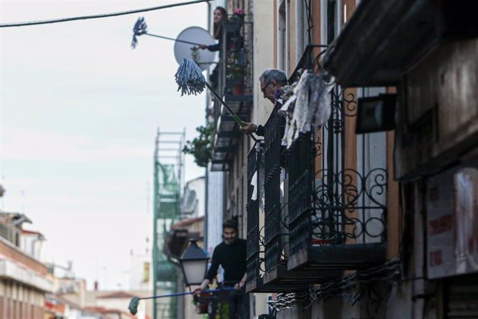 Vecinos del barrio madrileño de Lavapiés, realizan la 'Fregonada de Lavapiés', un gesto que consiste en agitar fregonas desde sus balcones para "limpiar el virus" cada día después del aplauso habitual a las 20h.