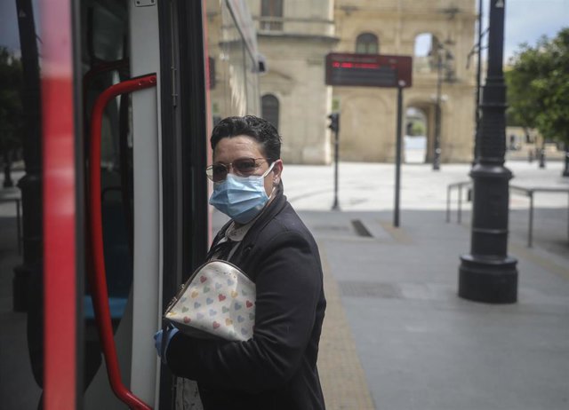Una mujer con mascarilla entra en el tranvía de Sevilla