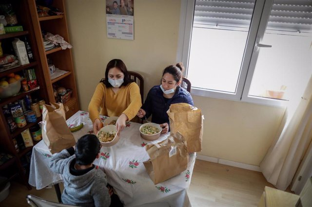 Dos mujeres y un niño durante la comida en su casa del barrio madrileño de Carabanchel.
