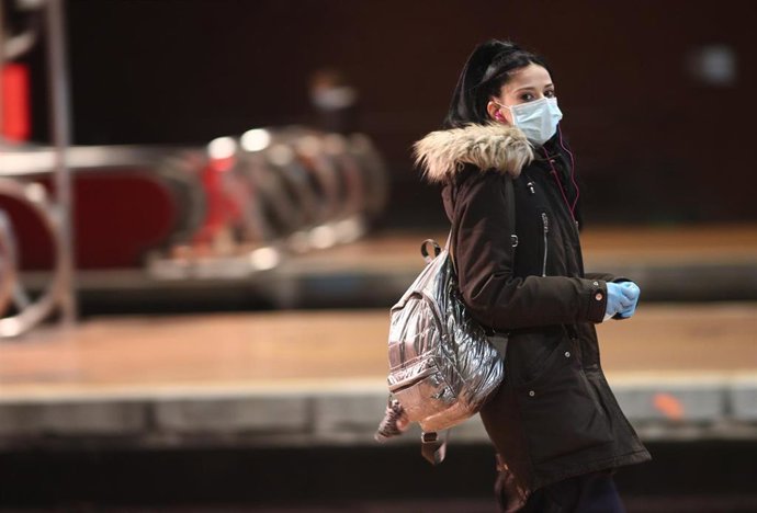 Viajeros esperan en uno de los andenes de Atocha donde la policía está entregando mascarillas a los usuarios de transporte público durante el segundo día de reparto de mascarillas en el transporte público.