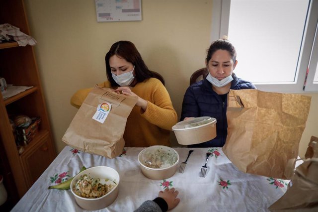 Dos mujeres durante la comida en su casa del barrio madrileño de Carabanchel abren el menú de la ONG del chef José Andrés, que reparte en Madrid a las familias más necesitadas durante el estado de alarma