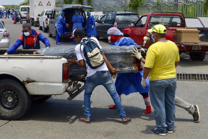 Un grupo de personas carga un ataúd en un coche en la ciudad ecuatoriana de Guayaquil durante la pandemia de coronavirus