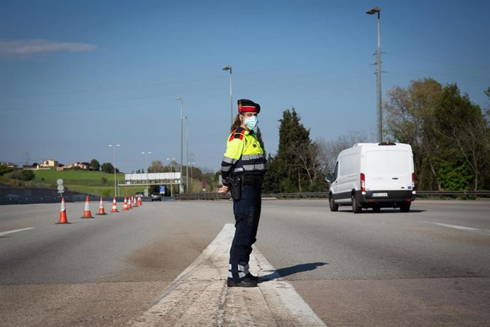 Una agente de los Mossos d'Esquadra protegida con una mascarilla en un control en el peaje de La Roca del Valls durante el Jueves Santo, en La Roca del Valls/Barcelona/Catalunya (España) a 9 de abril de 2020.