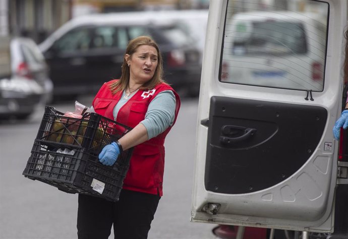 Personal de la Cruz Roja Española cargan una furgoneta de alimentos durante el cuarto día laborable del estado de alarma por coronavirus, (Covid-19). En Sevilla, (Andalucía, España), a 19 de marzo de 2020.