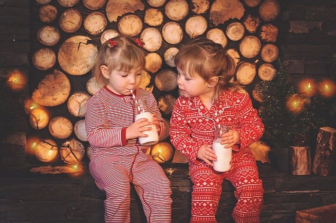 Niñas en pijama bebiendo leche.