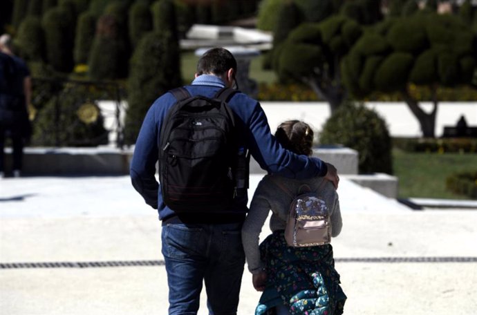 Un padre junto a su hija pasean por el Retiro en el primer día sin colegio por el riesgo del coronavirus. 11 de marzo. Archivo.