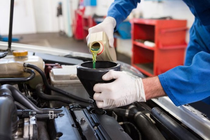 Imagen de archivo del cambio de aceite del motor de un coche en un taller mecánico