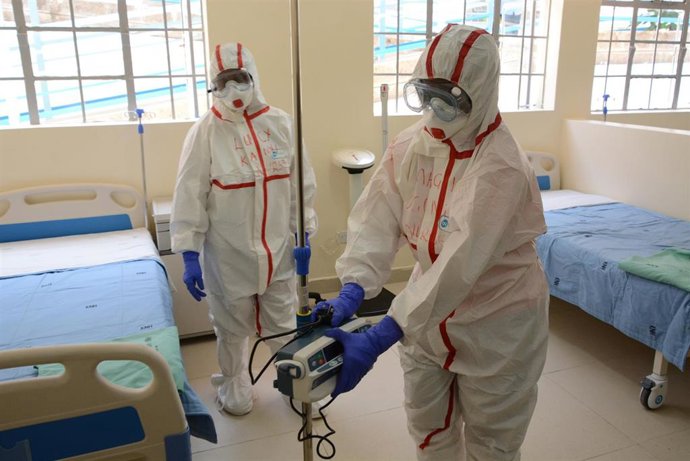 Dos trabajadores sanitarios con trajes de protección