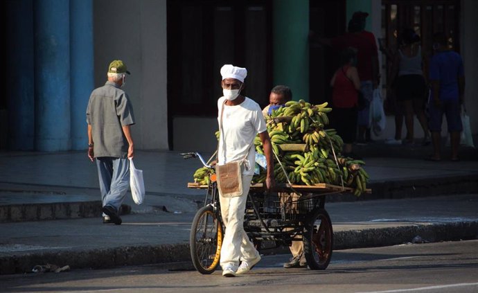 Un vendedor de bananas con mascarilla por el coronavirus en una calle de La Habana