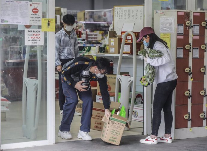 Personas de procedencia asiática salen de realizar sus compras