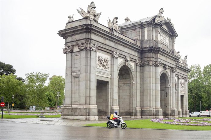 Un repartido de la empresa Glovo realiza un trayecto por la Puerta de Alcalá.