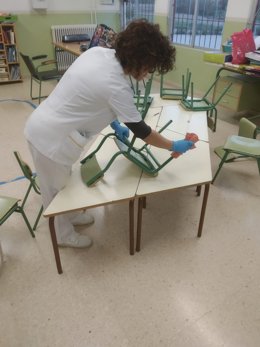 Una trabajadora limpia un aula infantil