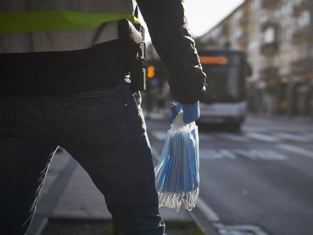 Un agente de la Policía Nacional se prepara para repartir mascarillas en Pamplona