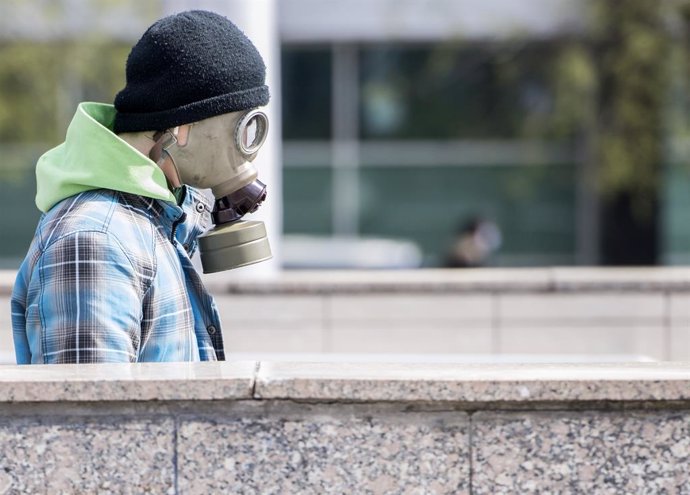Un hombre con una máscara antigás pasea por una calle de Bratislava