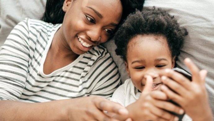 Una mujer y un niño utilizan un smartphone.