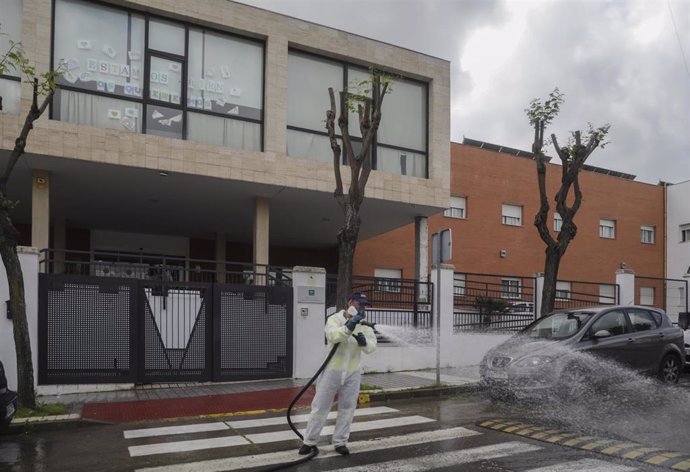 Personal del ayuntamiento desinfecta la calle del centro de personas mayores Joaquín Rosillo de San Juan de Aznalfarache 