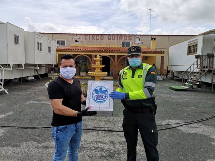 Un representante de Circos Reunidos entrega material de protección a un agente de la Guardia Civil.