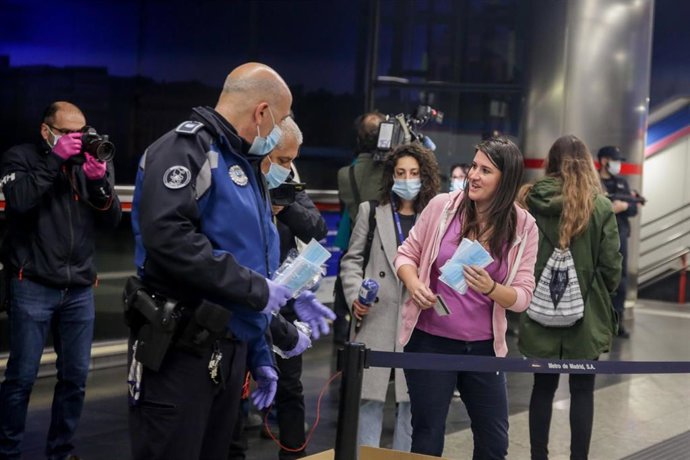 Agentes de la Policía Municipal de Madrid reparten mascarillas a viajeros en Metro