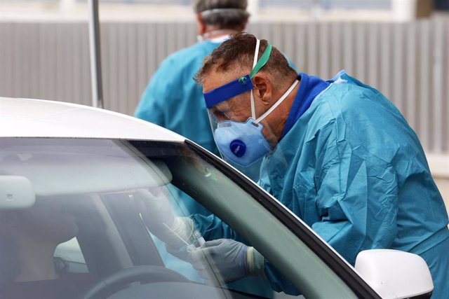 Dispositivo sanitario de la prueba test del PCR para detectar la infección por coronavirus a las personas desde su coche, instalado en el recinto de aparcamiento del centro de salud de la barriada La Roca, en Málaga, (Andalucía, España),
