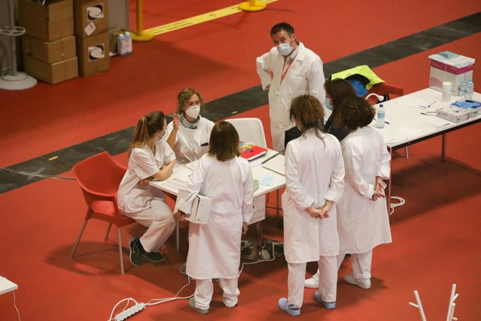 Trabajadores sanitarios protegidos hablan en el interior del hospital provisional específico sobre coronavirus montado en IFEMA.