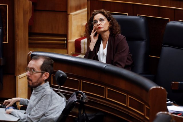 La ministra de Hacienda, María Jesús Montero (d), y el portavoz parlamentario de Unidas Podemos, Pablo Echenique, asisten a la primera sesión de control al Ejecutivo celebrada en el Congreso