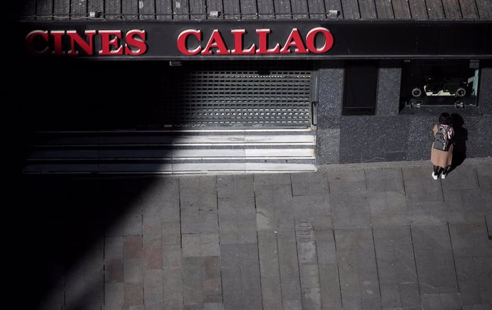 Una mujer se acerca a la ventanilla de los Cines Callao de Madrid el mismo día en el que han sido clausurados temporalmente ante el avance del coronavirus, en Madrid (España), a 13 de marzo de 2020.