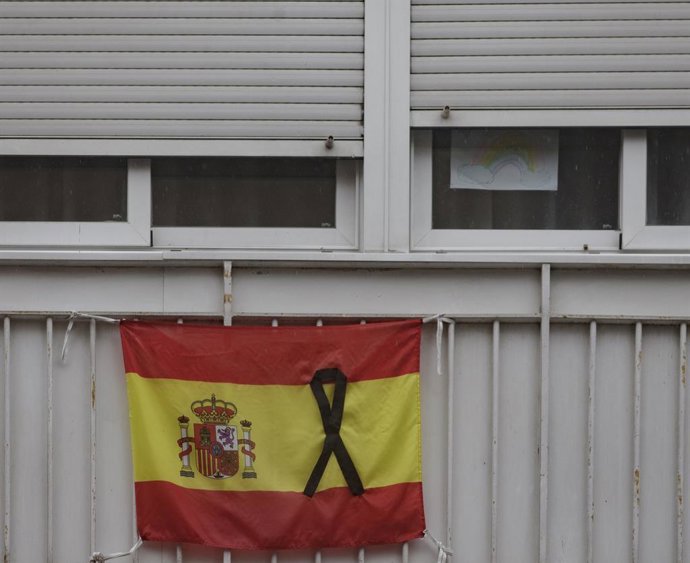 Una bandera de España colgada en un balcón con un crespón negro en recuerdo a los fallecidos por Covid-19. En Madrid, (España), a 15 de abril de 2020.