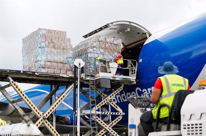 Trabajadores del aeropuerto bajan del avión carga sanitaria