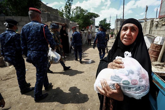 Una mujer con una bolsa de ayuda en Irak
