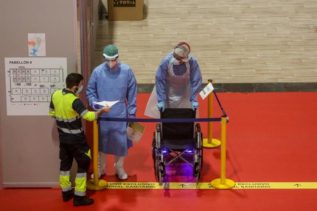 Trabajadores sanitarios protegidos se desplazan por el interior del Hospital de Campaña de Ifema