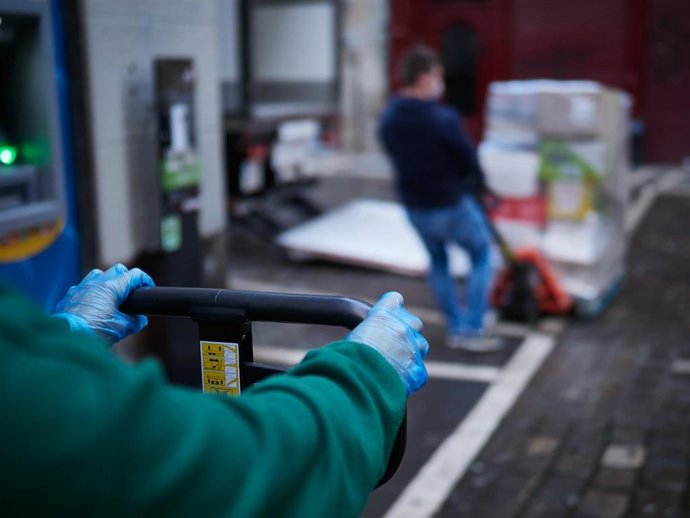 Un trabajador de reparto mueve productos de su camión aparcado en las calles de Pamplona que amanecen totalmente vacías durante la tercera semana de cuarentena y confinamiento total decretado en España como consecuencia del coronavirus, en Pamplona, Nav