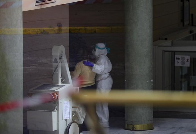 Personal sanitario ayuda a una anciana en el interior del Hotel Alcorá tras ser adaptado como hospital para recibir pacientes con coronavirus. En Sevilla, (Andalucía, España), a 30 de enero de 2020.