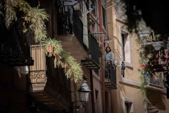 Un hombre se asoma al balcón durante el tercer día laborable del estado de alarma por coronavirus, en Barcelona/Catalunya (España) a 18 de marzo de 2020.