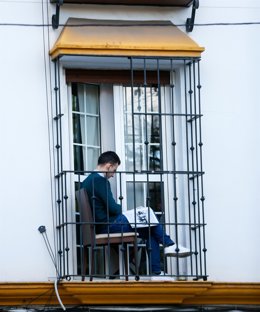 Un ciudadano lee en su balcón durante el confinamiento por el coronavirus. 