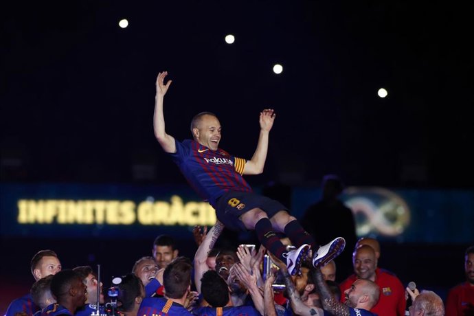 Andrés Iniesta, manteado por sus compañeros del FC Barcelona, tras su último partido con el equipo