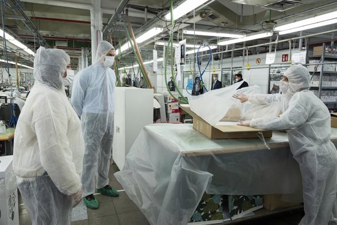 El presidente del Gobierno, Pedro Sánchez (2i), acompañado por la presidenta de El Corte Inglés, Marta Álvarez (1i), observan el trabajo de una costurera durante su visita a los talleres de confección que El Corte Inglés tiene en Madrid.