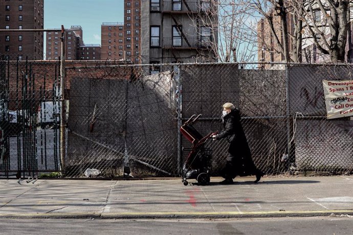 Una mujer con mascarilla andando por las calles de Nueva York