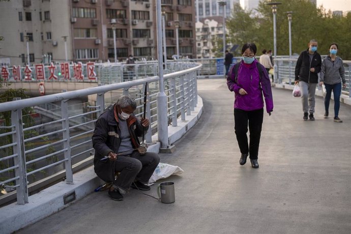 Imagen de varias personas en Shanghái con mascarilla por el coronavirus.