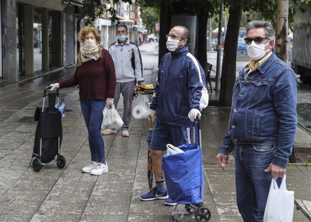 Vecinos guardan turno para comprar en la calle Marqués de Pickman durante la quinta semana del estado de alarma por la crisis del coronavirus, (Covid-19). En Sevilla, (Andalucía, España), a 15 de abril de 2020.